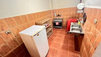 a small kitchen with a sink and a refrigerator at Family Flat With Breakfast in Luxor