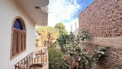 a building with a staircase next to a brick wall at Family Flat With Breakfast in Luxor