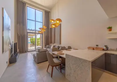 a kitchen and living room with a table and a couch at Prime 4BR Villa in Ancient Sands, El Gouna Private Swimming Pool & Lagoon Access in Hurghada
