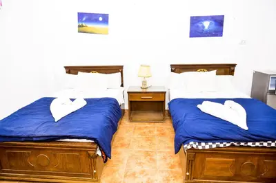 a bedroom with two beds with white towels on them at Flamingo Memnon Guest House in Luxor