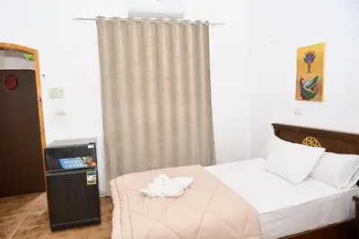 a bedroom with a bed with a flower on it at Flamingo Memnon Guest House in Luxor