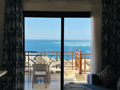 a room with a balcony with a view of the ocean at The view -Nubian One bedroom in Hurghada