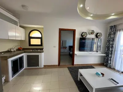 a living room with a table and a tv in it at The view -Nubian One bedroom in Hurghada
