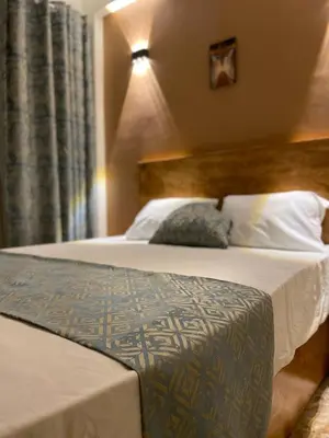 a bedroom with a bed with a wooden headboard at Luxe Nest Luxor Serviced Apartments 102 in Luxor