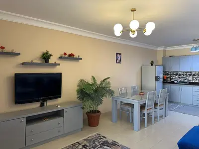 a living room with a television and a table with chairs at The Nubian Two-Bedroom Apartment in Hurghada