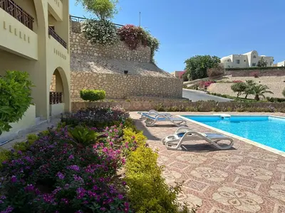 a resort with a swimming pool and flowers next to a building at The Hill House in Hurghada