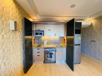 a kitchen with white and black appliances in a room at The Hill House in Hurghada