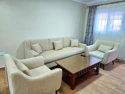 a living room with a couch and two chairs and a table at Elnahla Villa in Hurghada