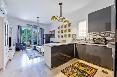 a kitchen with a counter and a living room at Townhouse with roof terrace,balcony and large pool in Hurghada