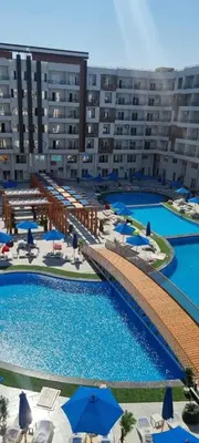 an aerial view of a large swimming pool with umbrellas at Sami and Sam studio apartment in Hurghada