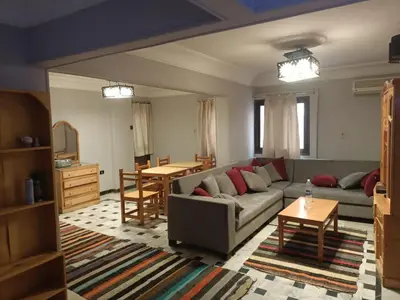 a living room with a couch and a table at fayrouz apartment in Jazīrat al ‘Awwāmīyah