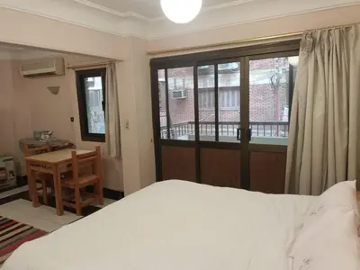 a bedroom with a bed and a desk and a window at fayrouz apartment in Jazīrat al ‘Awwāmīyah