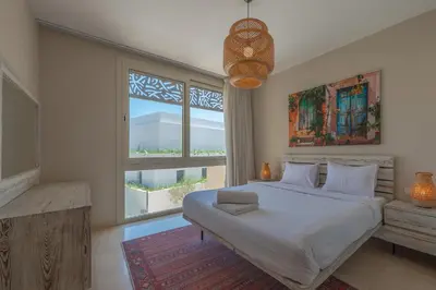 a bedroom with a large bed and a large window at Cozy One Bedroom in Mangroovy in Hurghada