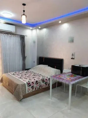a bedroom with a bed and a table in it at Compound El makramia 504 in Hurghada