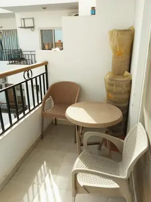 a small table and chairs on a balcony at Compound El makramia 504 in Hurghada