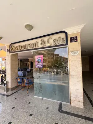 a restaurant and coffee shop with a sign over the window at Stefy Holiday Hurghada in Hurghada