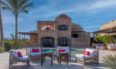 a patio with chairs and tables in front of a house at Luxury Stays in West Golf El Gouna in Hurghada
