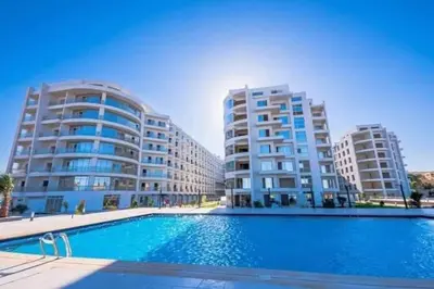 a swimming pool in front of two tall buildings at سكانديك ريزورت in Hurghada