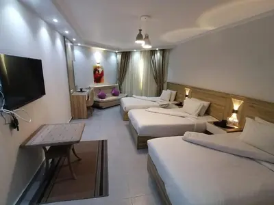 a hotel room with two beds and a flat screen tv at سكانديك ريزورت in Hurghada