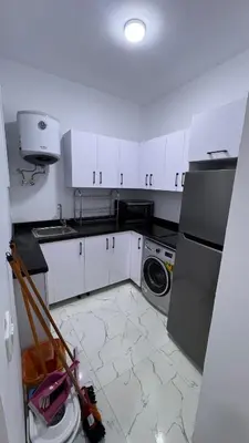 a kitchen with white cabinets and a washer at Stunning sea view Apartment in Hurghada