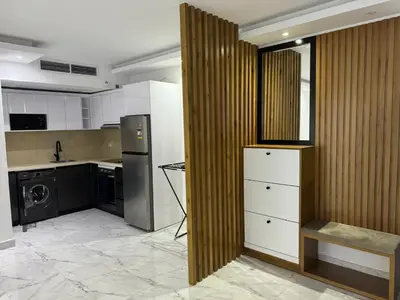 a kitchen with white cabinets and a washer and dryer at Fanadir L406 in Hurghada