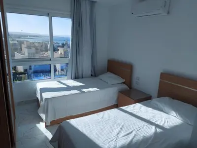 two beds in a room with a large window at Fanadir L406 in Hurghada