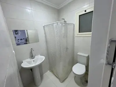 a white bathroom with a toilet and a sink at Avin Resort Hurghada in Hurghada