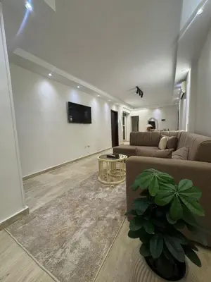 a living room with a couch and a tv on a wall at Avin Resort Hurghada in Hurghada