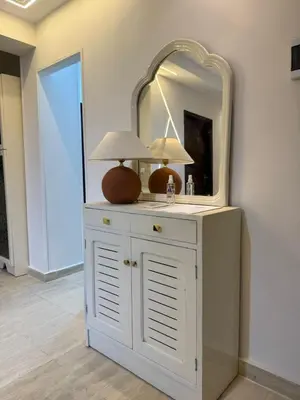 a white dresser with a mirror and lamps on it at Avin Resort Hurghada in Hurghada