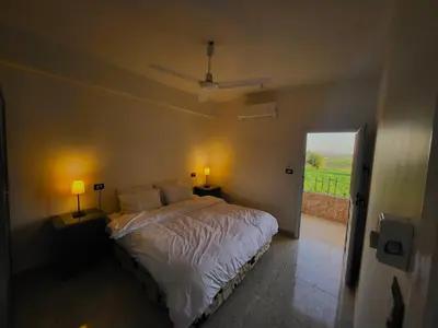 a bedroom with a bed with two lamps and a window at Casablanca guest house᭄ꦿ in Luxor