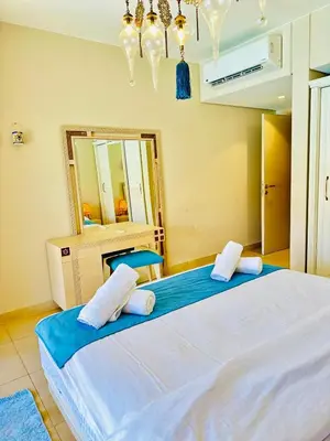 a large bed in a room with a mirror at Cozy apartment in Mangroovy in Hurghada
