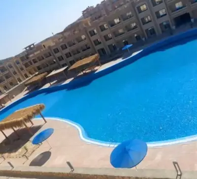 a large swimming pool in front of a hotel at Sahl hashesh Resort in Hurghada