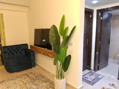 a living room with a black chair and a plant at Sahl hashesh Resort in Hurghada