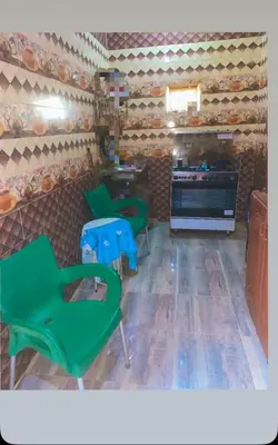 a room with three green chairs and a stove at Nubian night in Jazīrat Suhayl