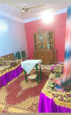 a room with two beds and a table in it at Nubian night in Jazīrat Suhayl