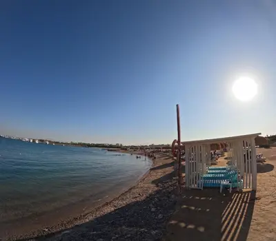 a beach with some chairs and the water at avenue compound in Hurghada