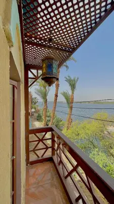 a balcony of a house with a view of the ocean at Yellow House on the Nile in Luxor