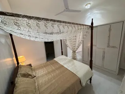 a bedroom with a bed with a canopy and a curtain at Villa Golden Mountain in Luxor