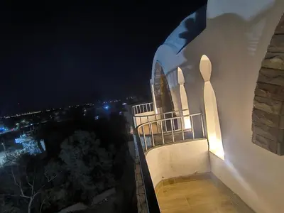 a night view of a building with a balcony at King House in Luxor