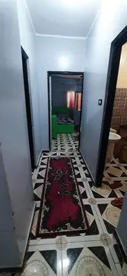 a hallway with a red rug on the floor at Downtown Apartment in Aswan