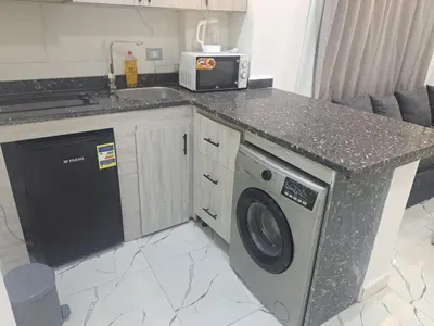 a kitchen with a washing machine and a sink at Amazing Roof In Marina Hurghada in Hurghada