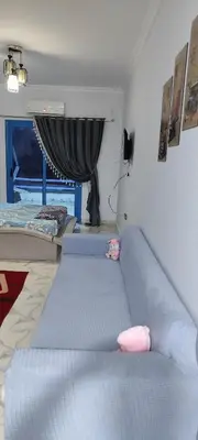 a living room with a blue couch and a window at اويسيس مارينا in Hurghada