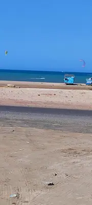 a beach with two boats in the water and a boat at اويسيس مارينا in Hurghada