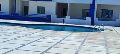a swimming pool in front of a building at اويسيس مارينا in Hurghada