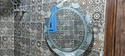 a bathroom with a mirror on a tiled wall at Oasis marina in Hurghada