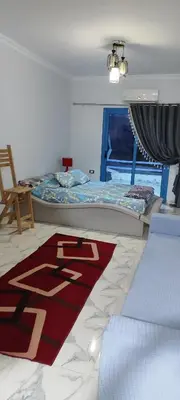 a bedroom with a bed and a rug on the floor at Oasis marina in Hurghada