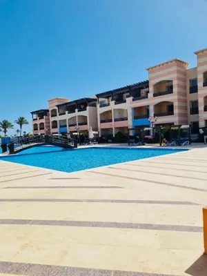 an empty swimming pool in front of a building at Apartment in Port Ghalib Marina City in Port Ghalib