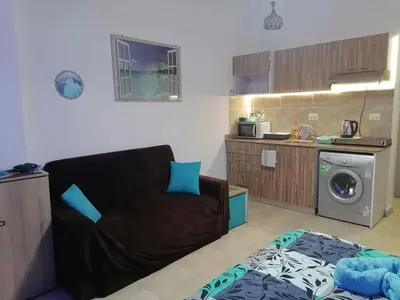 a living room with a couch and a kitchen at Studio Sheraton Plaza in Hurghada