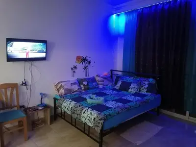 a bedroom with a bed and a tv in a room at Studio Sheraton Plaza in Hurghada