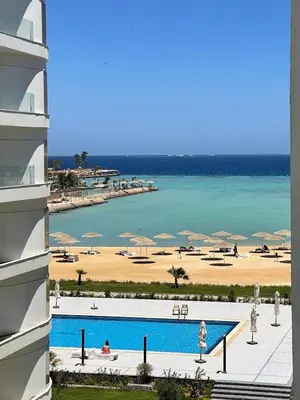 a view of a resort with a beach and a swimming pool at Seafront Hotel Apartment with private beach in Hurghada